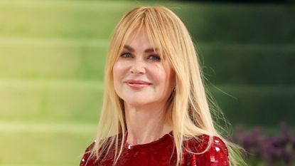 Image of Nicole Kidman smiling at the Met Gala 2026, with golden blonde straight hair and fringe, wearing a red sequin gown