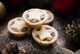 Mince pie shortage Christmas 2021 Three small Mince Pies, dusted with icing sugar with Christmas decorations.