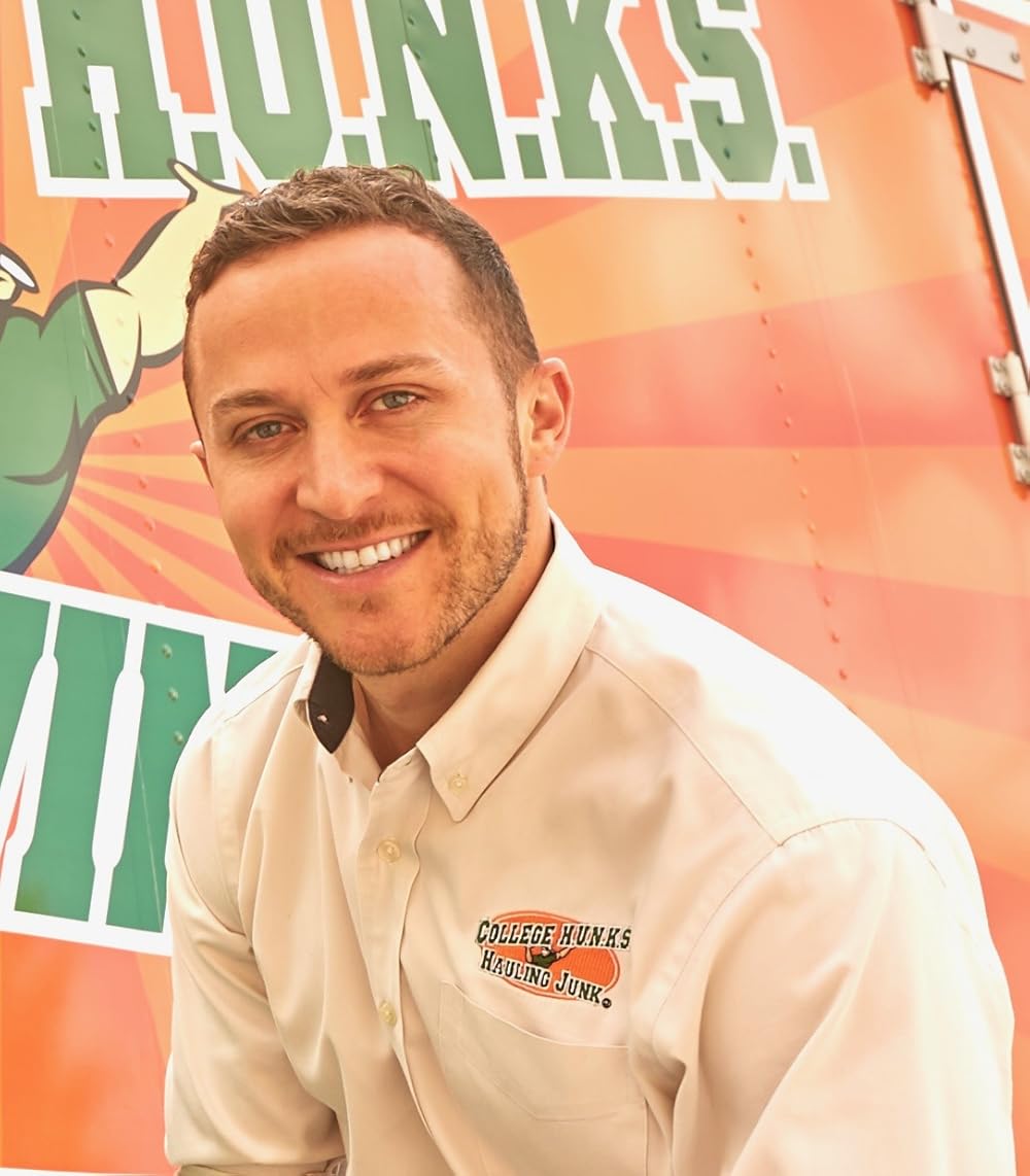 Nick is pictured in a work shirt with the orange and black oval company logo on his top left pocket. 