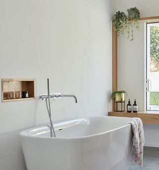 bathroom with white bathtub and white walls
