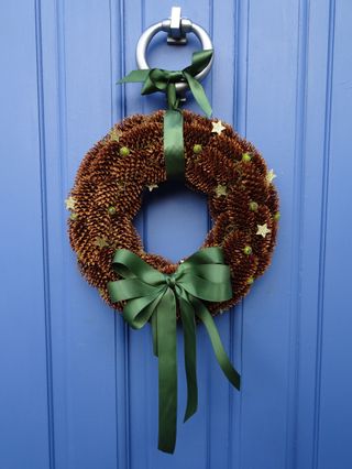 pine cone wreath with green ribbon
