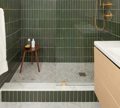 How to unclog a shower drain – shower tray with drain and green tiles