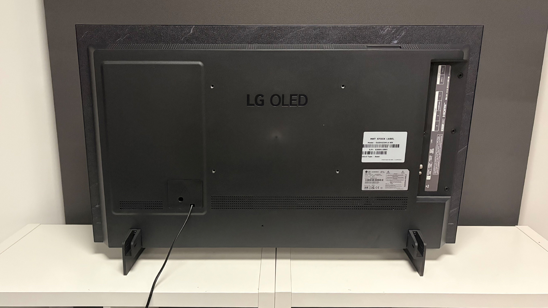 LG C6 42-inch OLED TV on white shelving unit in test room, rear of set