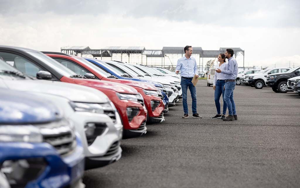 Dealer showing cars to couple