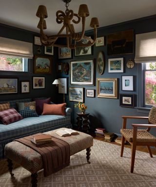 navy blue snug family room with a gallery wall and a blue plaid couch with patterned cushions and a neutral woven rug