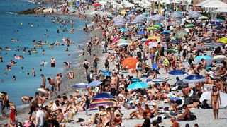 Tourists enjoy the beach along the "Promenade des Anglais" on the French riviera city of Nice, on July 14, 2025.