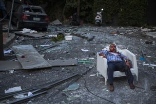 BEIRUT, LEBANON - AUGUST 04: (EDITORS NOTE: Image contains graphic content.) An injured man rests in a chair after a large explosion on August 4, 2020 in Beirut, Lebanon. Video shared on soci