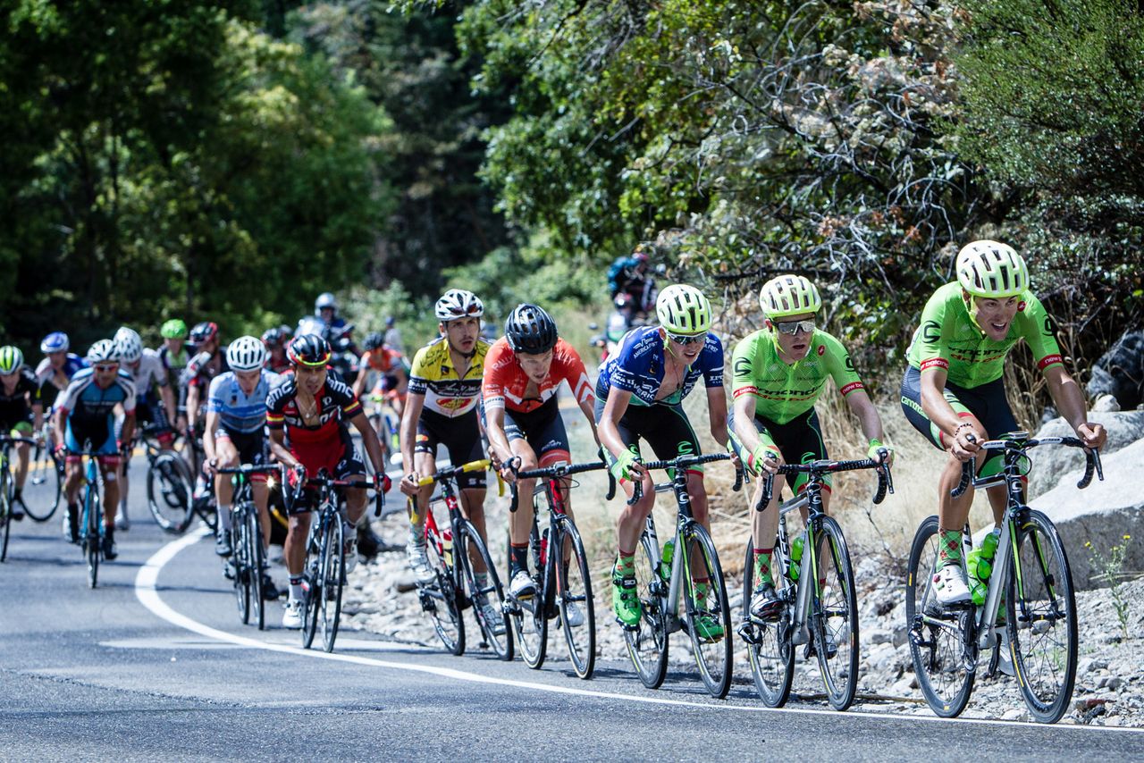 Riders climb Little Cottonwood Canyon as the TV moto goes down in the background