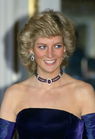 Diana, Princess Of Wales, Wearing A Purple Velvet Sleeveless Evening Dress Designed By Catherine Walker With Matching Choker And Earrings For A Performance Of Mozart's Opera "marriage Of Figaro" At The Munich Opera House During Her Official Visit To Germany
