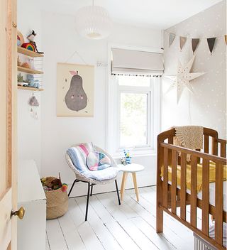 Scandi style nursery with wooden cot and wall poster