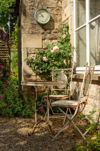 Garden in bath with bistro table and chairs near the house