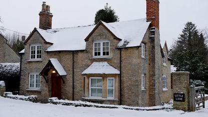 exterior of brick cottage covered in snow