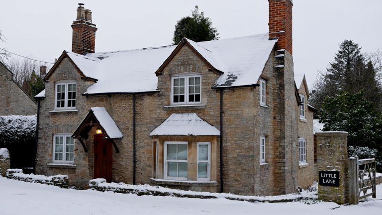 exterior of brick cottage covered in snow