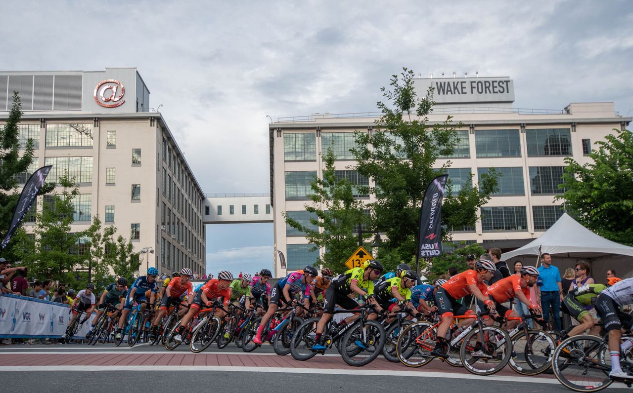 The mens peloton rolls through the first turn of the criterium