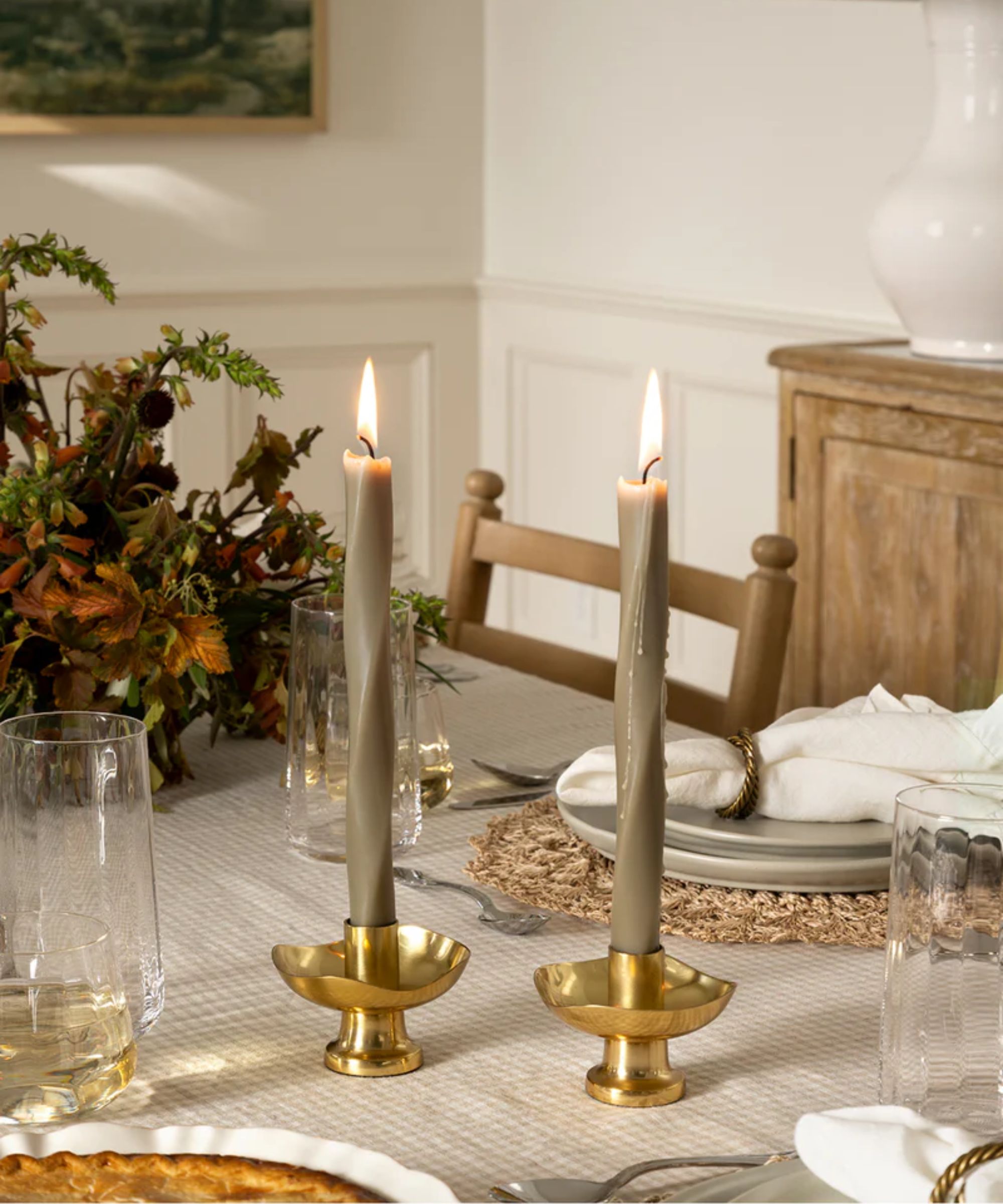 Table with sage green twist taper candles, gold candle holders, sage green plates and gingham tablecloth