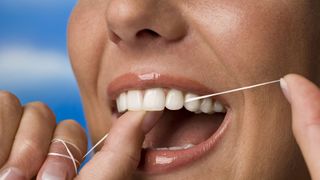 How often should you floss your teeth? image shows woman flossing teeth