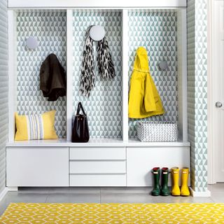 hallways storage unit with coat hooks and a graphic print wallpaper and rug coats and wellies