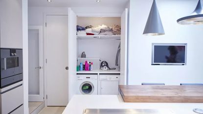 a white modern kitchen with one of the quietest washing machines located in it