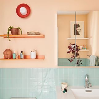 Coral bathroom space with blue tile and orange shelving