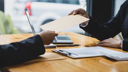 an attorney hands a document to a client