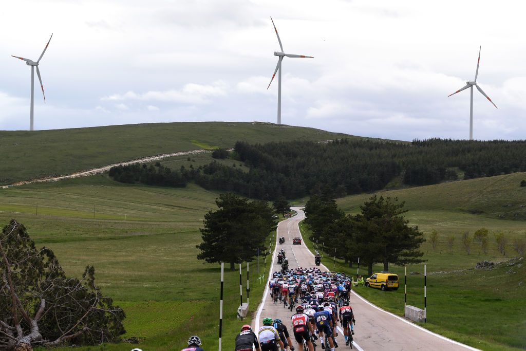 CAMPO FELICE ROCCA DI CAMBIO ITALY MAY 16 The Peloton passing through Nomi 179m during the 104th Giro dItalia 2021 Stage 9 a 158km stage from Castel di Sangro to Campo Felice Rocca di Cambio 1665m Landscape Windmill girodiitalia Giro UCIworldtour on May 16 2021 in Campo Felice Rocca di Cambio Italy Photo by Tim de WaeleGetty Images