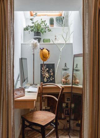 Home office nook with wall-hung desk, wooden chair, rooflight overhead and natural accessories