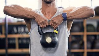 Man doing upright row exercise with kettlebell 