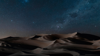 Dunes under starry night sky, Namib Desert. 