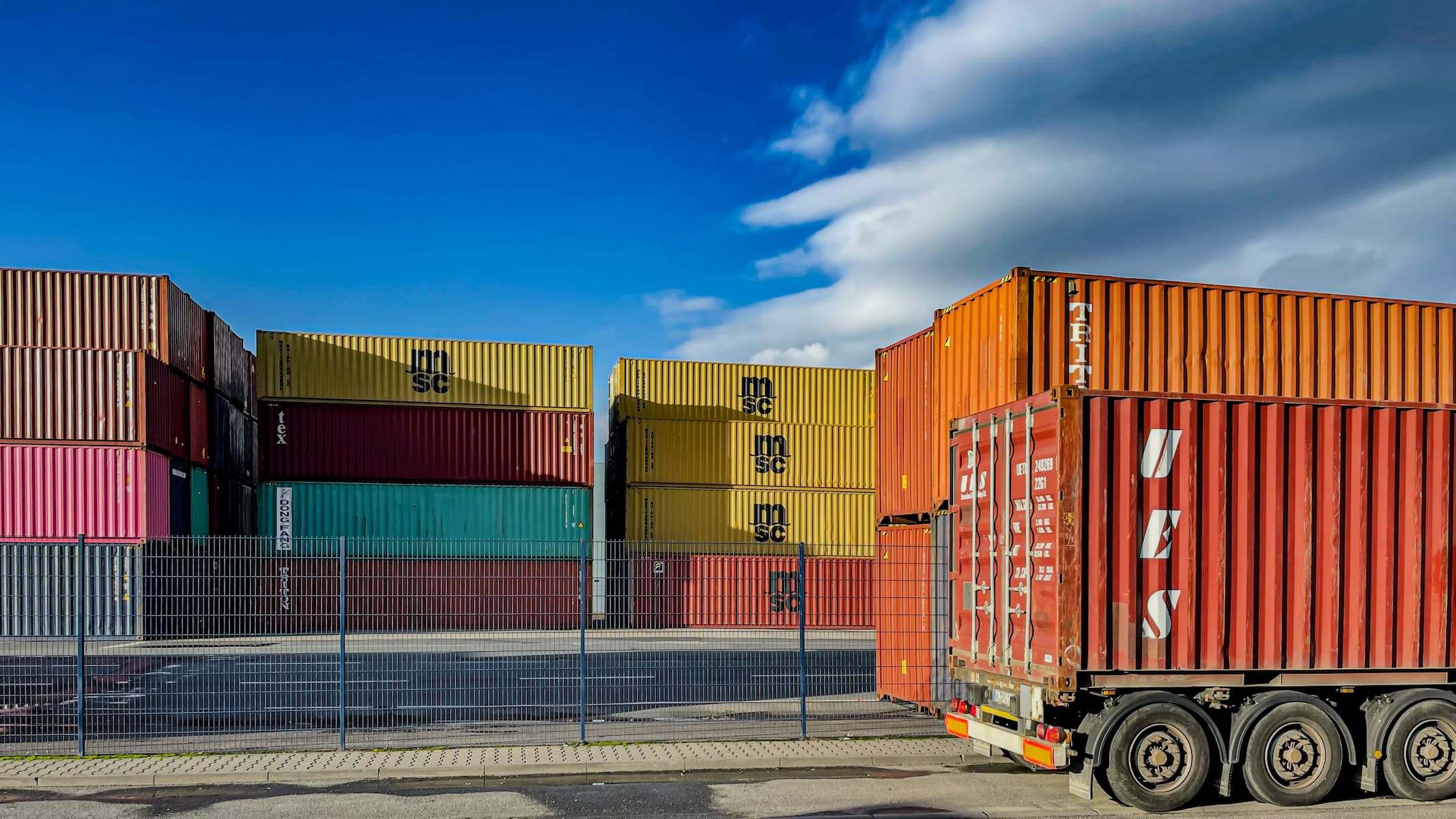 Shopping containers and trucks against a blue sky