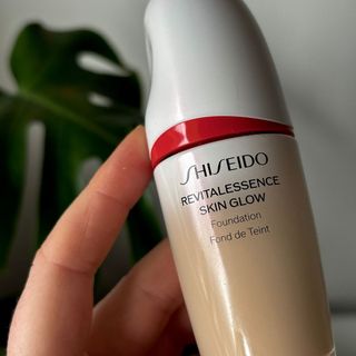 A closeup of Laura holding a bottle of Shiseido Revitalessence Glow Foundation