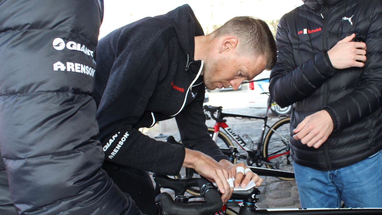 Sunweb's Tom Stamsnijder, with taped fingers, tapes on his sector menu