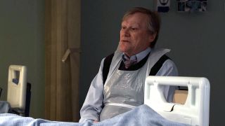 Roy sits by Nina's hospital bed in Coronation Street
