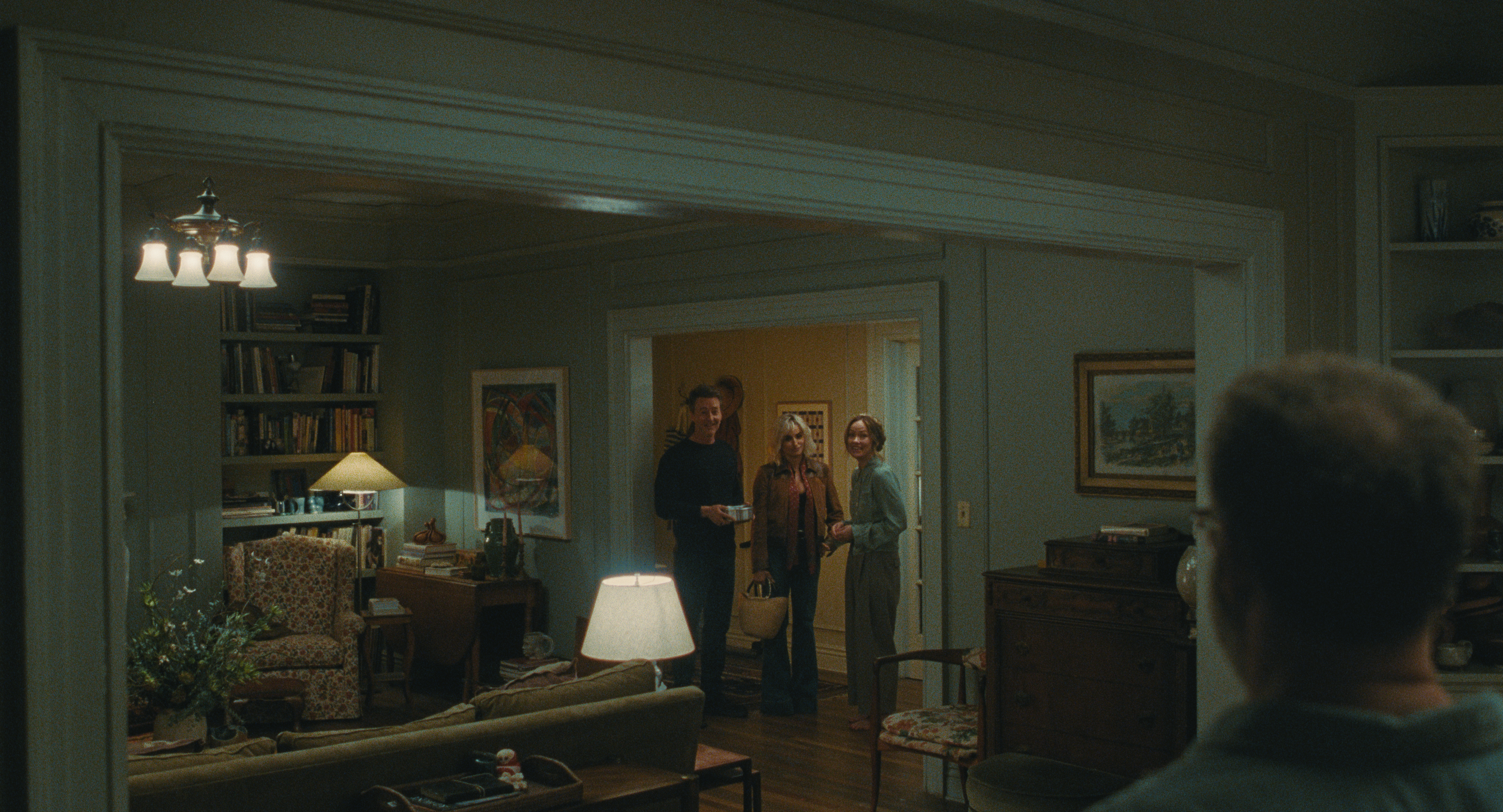 a shot of the apartment in the movie the invite featuring vintage furniture and dimly lit lamps as couple angela and joe welcome guests pina and hawk into their home
