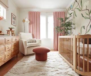 neutral nursery with a floral mural and pink and wooden accents