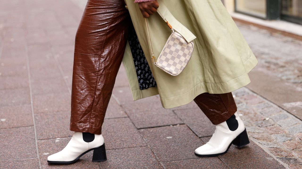 Influencer Lois Opoku wearing a mini bag by Louis Vuitton and white Chelsea boots by Monki, seen during Copenhagen Fashion Week Autumn/Winter 2022 on February 2, 2022 in Copenhagen, Denmark. 