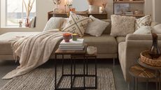 A cozy, neutrally-decorated living room with large sofa and assortment of lit candles