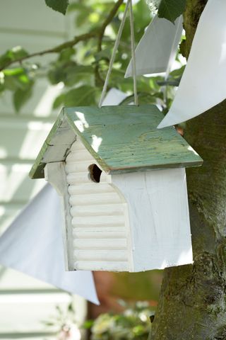 bird house design ideas: white and green bird house with bunting