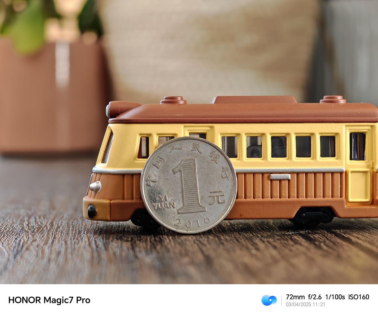 A coin propped up against a train on a wooden table