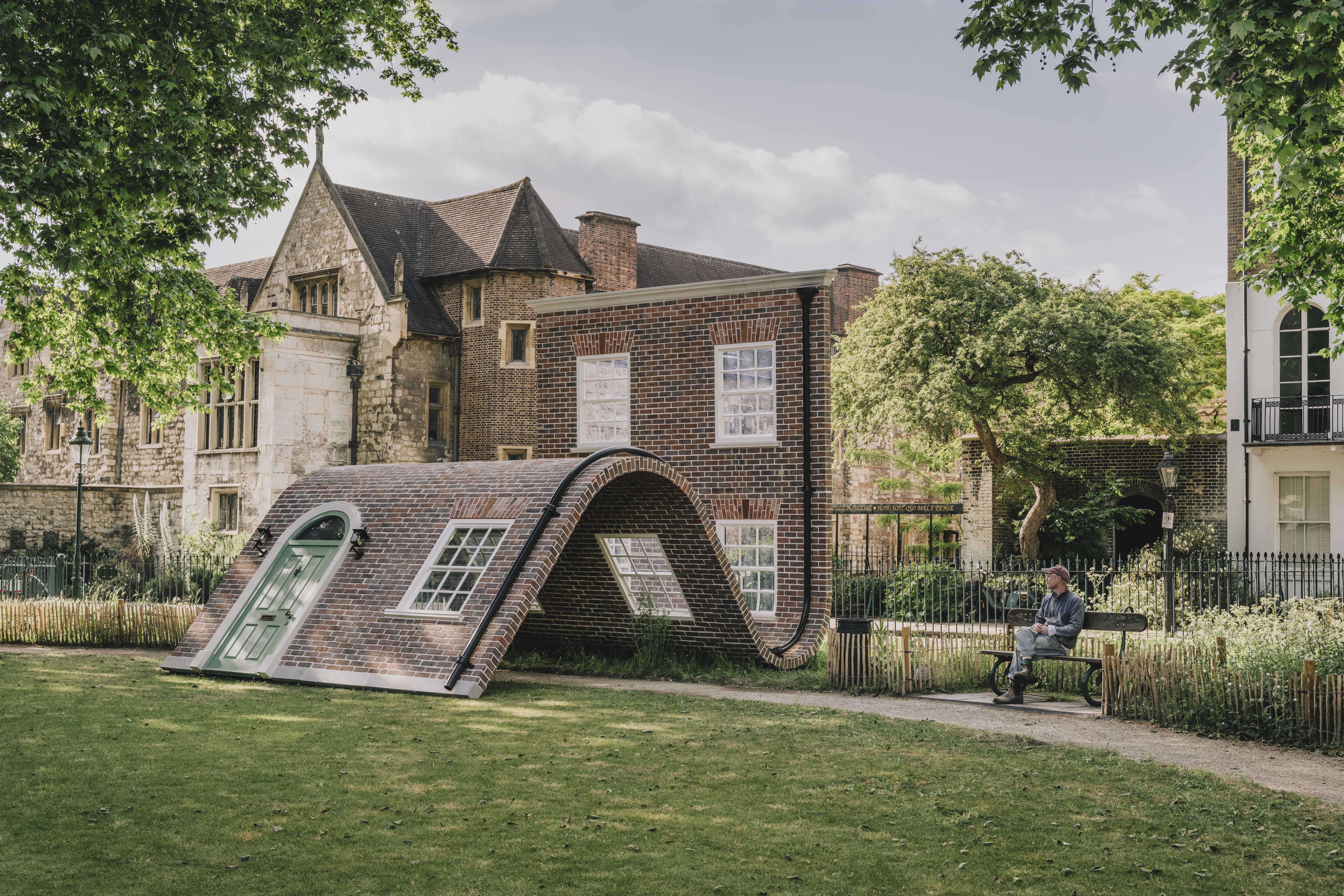 surrealist sculpture that resembles bent brick house facade