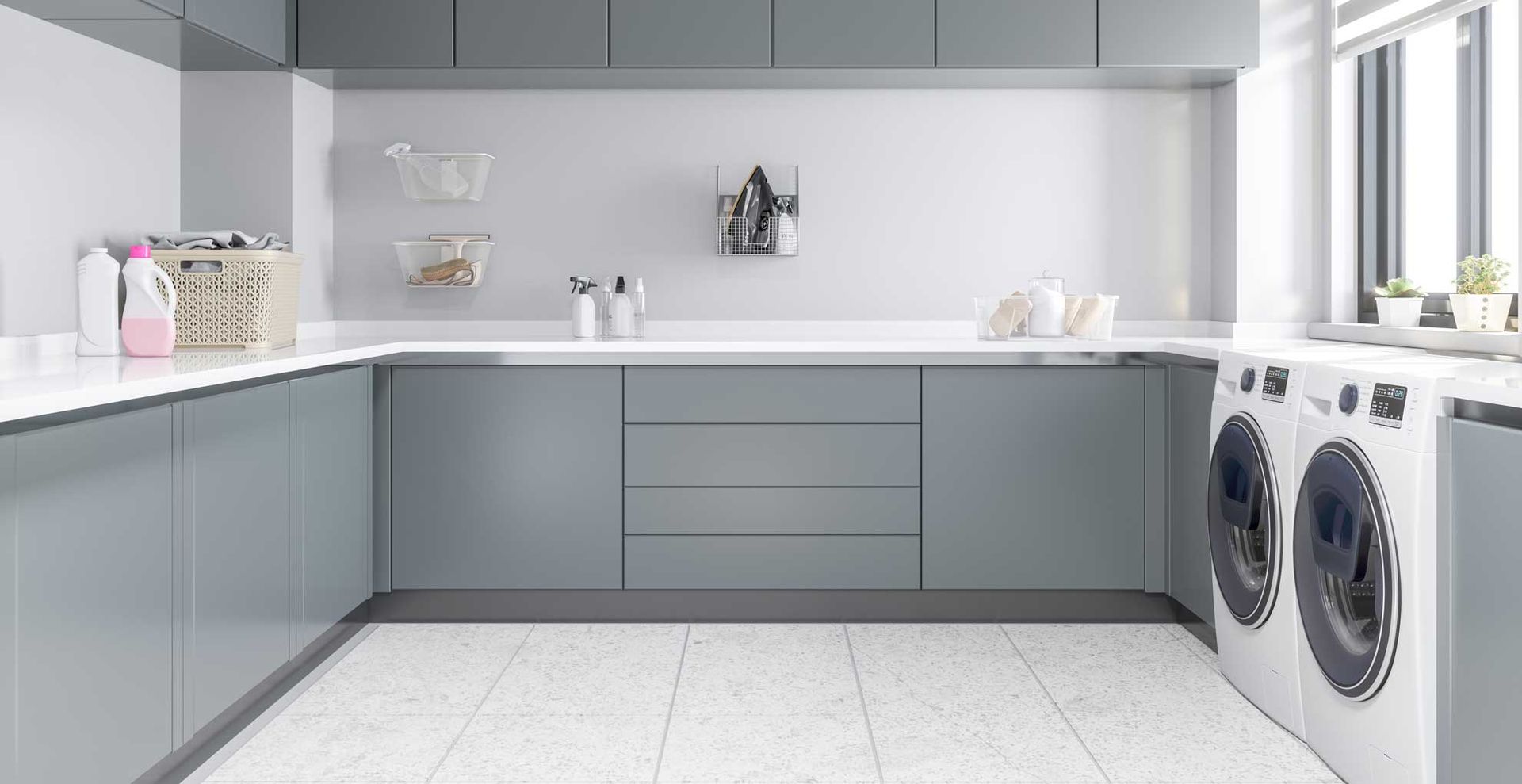 clear and tidy organized laundry room with gray cabinets and white counter tops