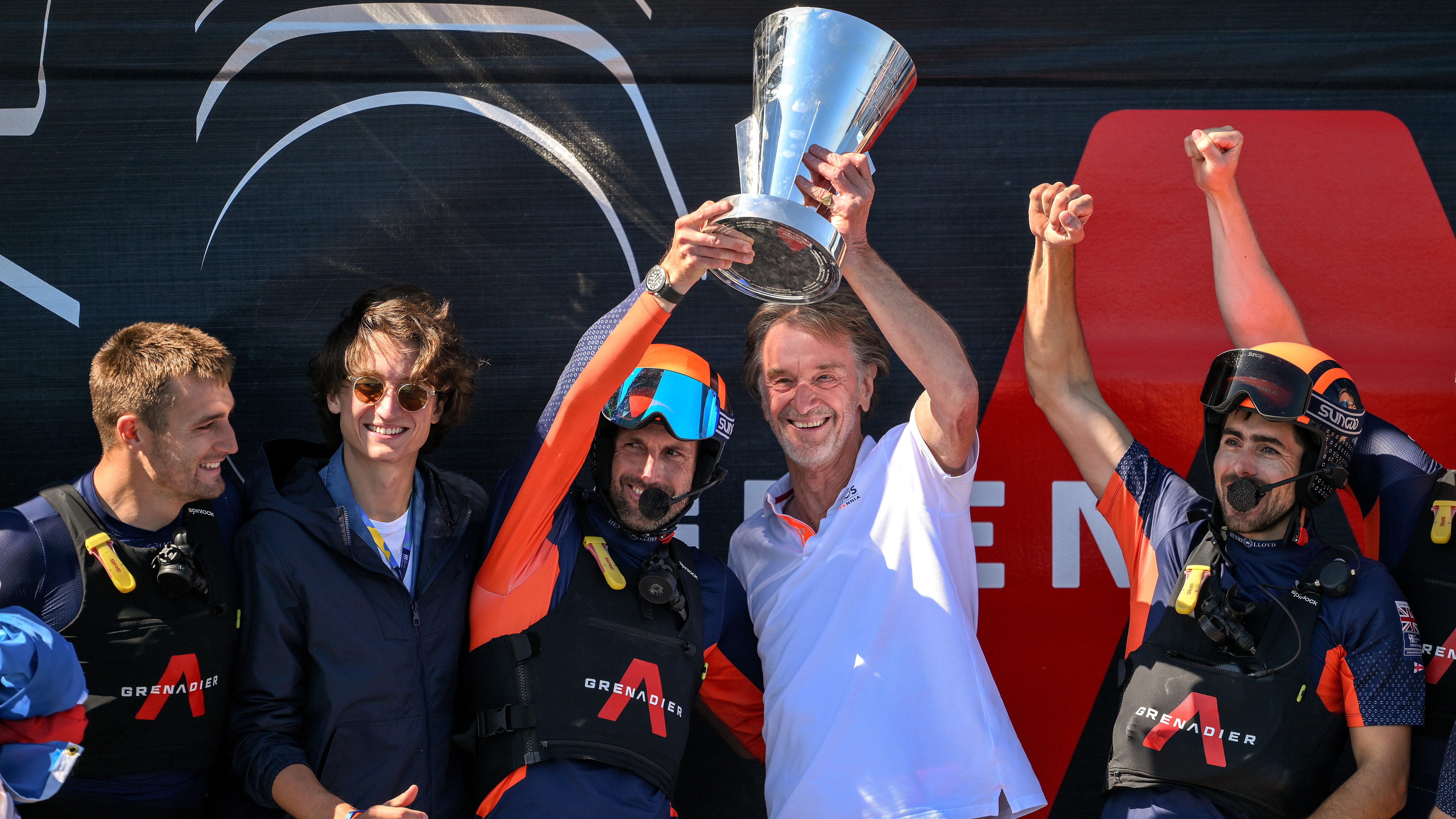 Sir Ben Ainslie skipper of the AC75 Ineos Britannia and Ineos CEO Sir Jim Ratcliffe celebrate with the Louis Vuitton Cup after defeating The AC75 Luna Rossa Prada Pirelli Team during the race 11 of the Louis Vuitton Cup Final - 37th America's Cup on October 04, 2024 in Barcelona, Spain