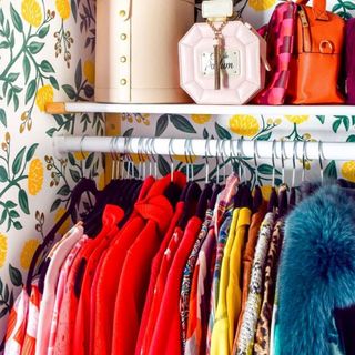 Color coordinated wardrobe detail with cheerful floral wallpaper