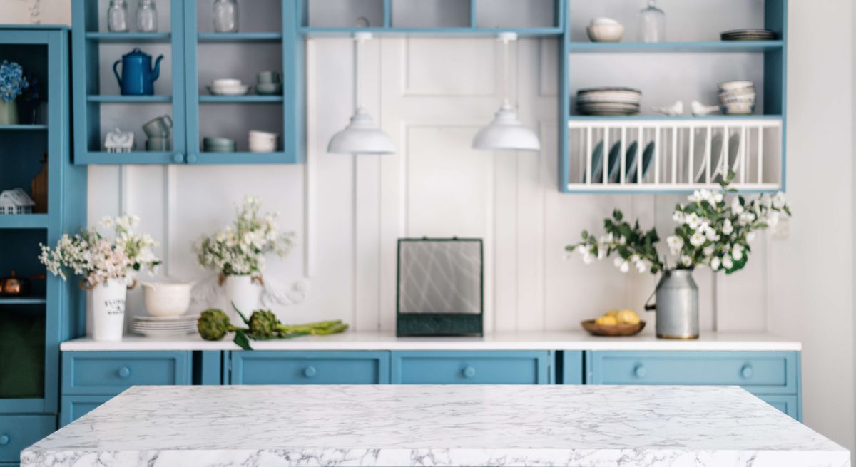 Blue painted kitchen cabinets with a marble worktop