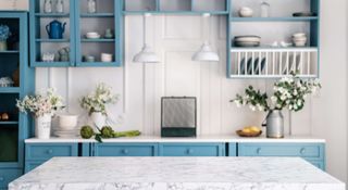 Blue painted kitchen cabinets with a marble worktop