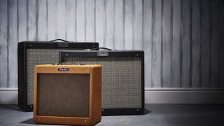Three Fender amps against a wooden wall
