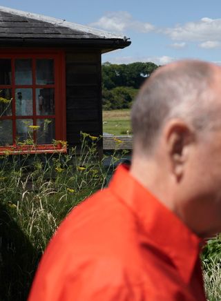 Ben Kelly in his garden in an orange shirt