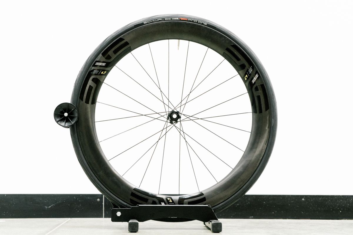 An aero road wheel stands against a white wall
