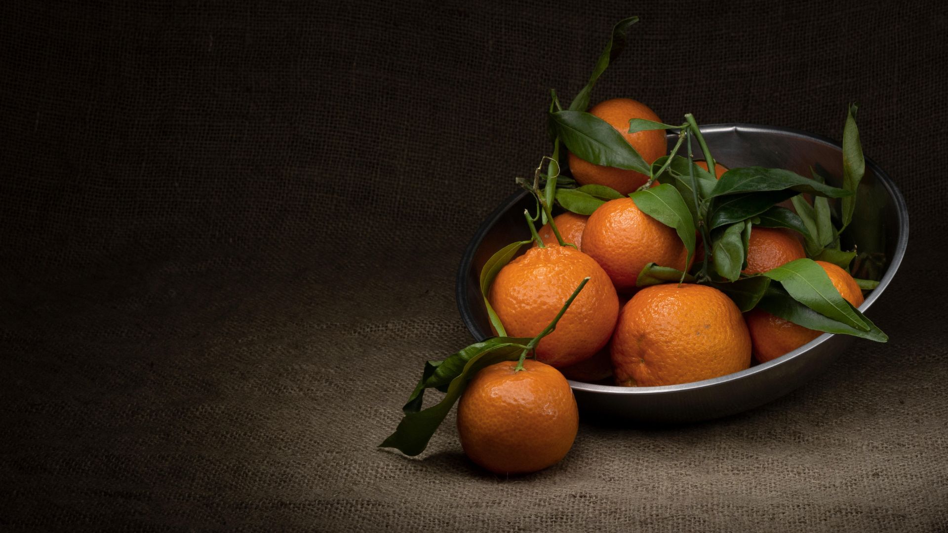 A silver bowl of freshly cut oranges