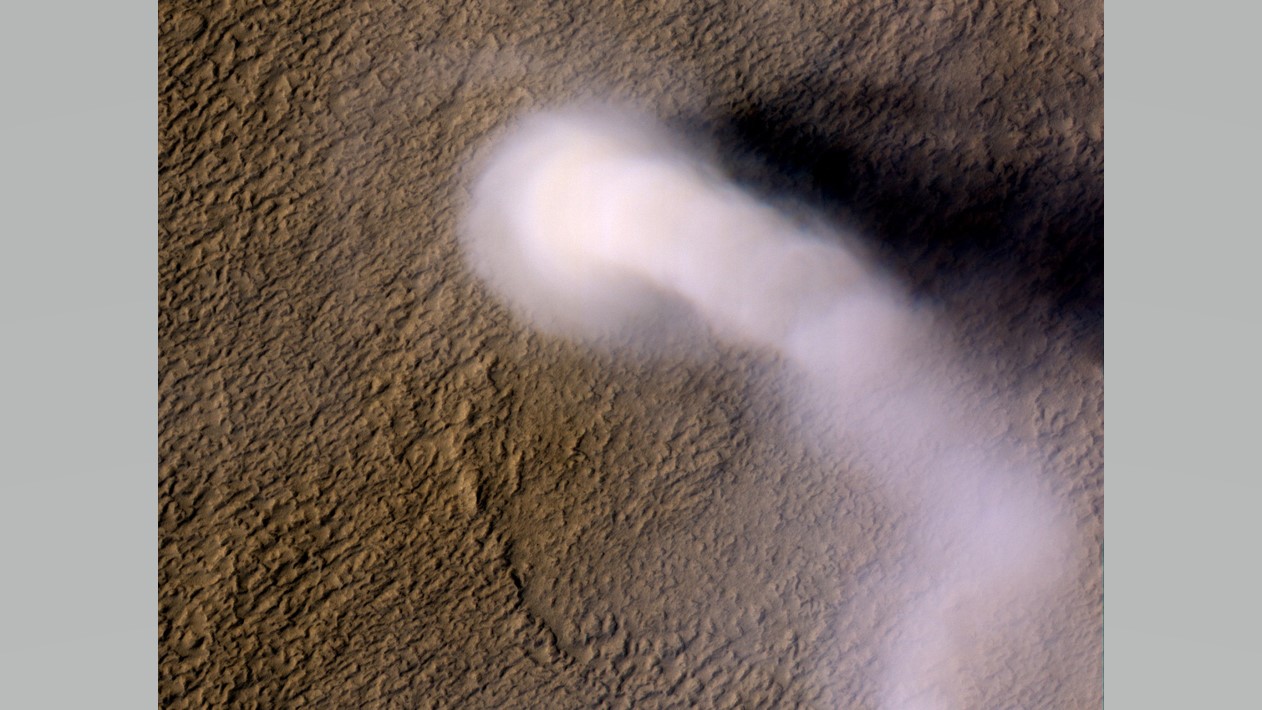 A dust devil seen from above by the Mars Reconnaissance Orbiter's HiRISE camera. The plume is about 230 feet (70 meters) wide and 12 miles (20 kilometers) high.