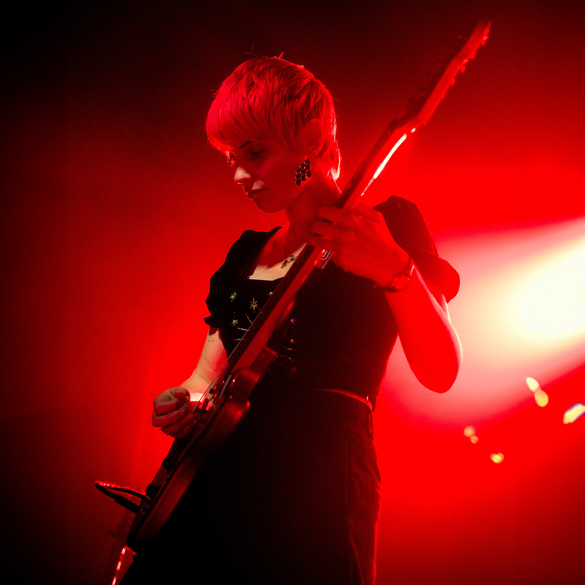 Janelle Borg on stage with a guitar